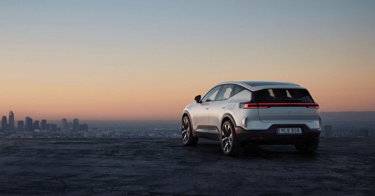 Polestar 3 parked, city skyline on horizon, sky at sunset