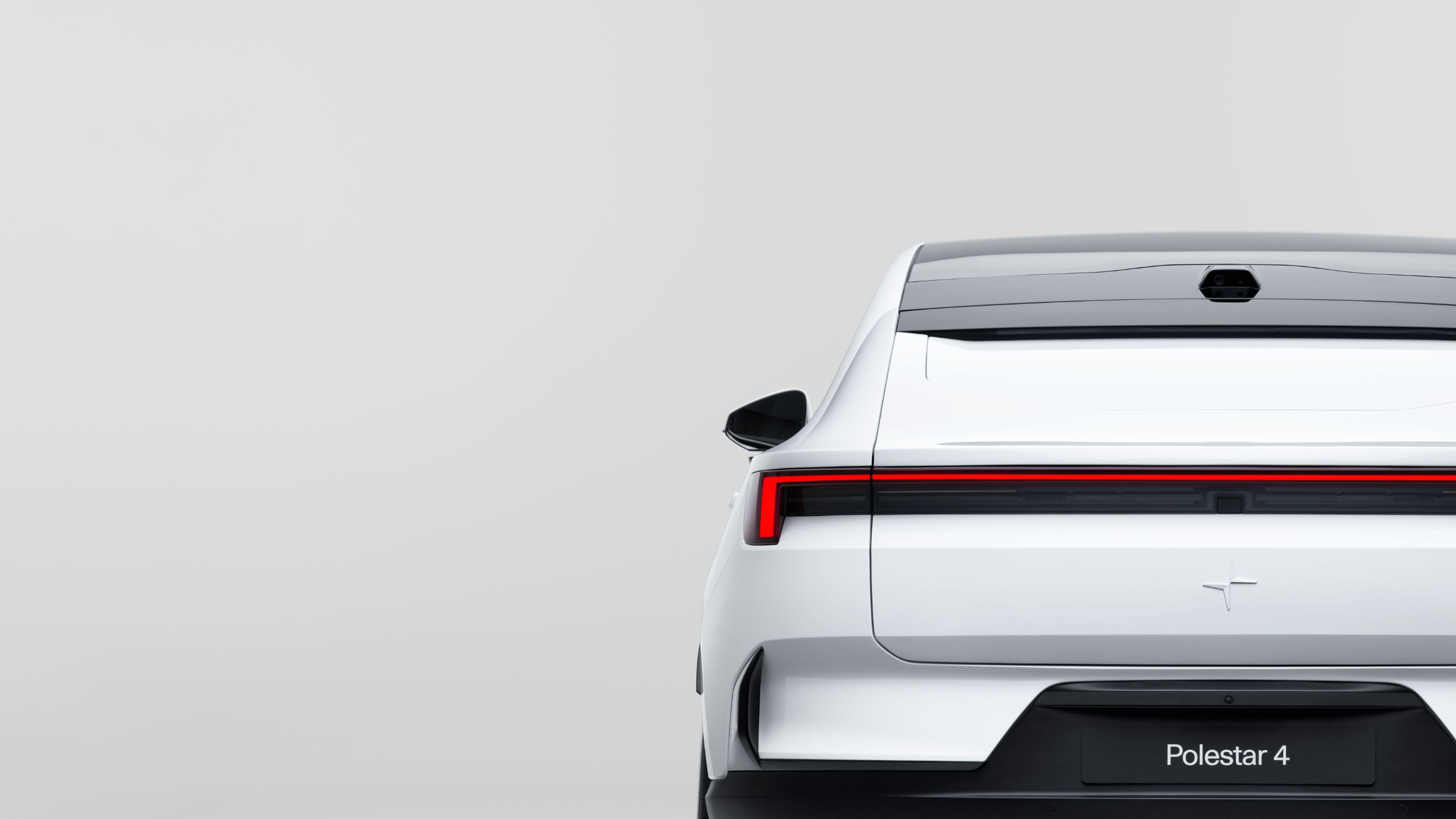 Rear view of Polestar 4 with red tail light, white body, and Polestar logo on a light gray background.