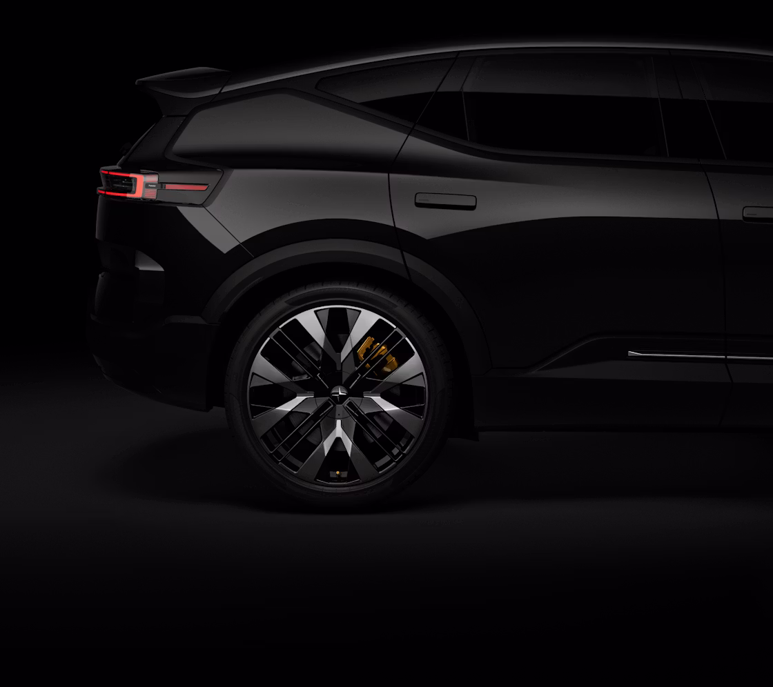 Partial side view of a black Polestar 3 against a black backdrop with gold brake calipers.