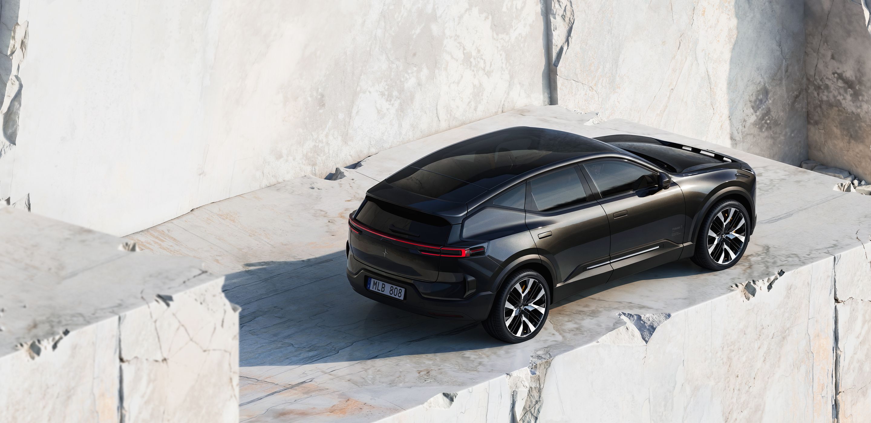 A black Polestar 3 parked on a stone ledge