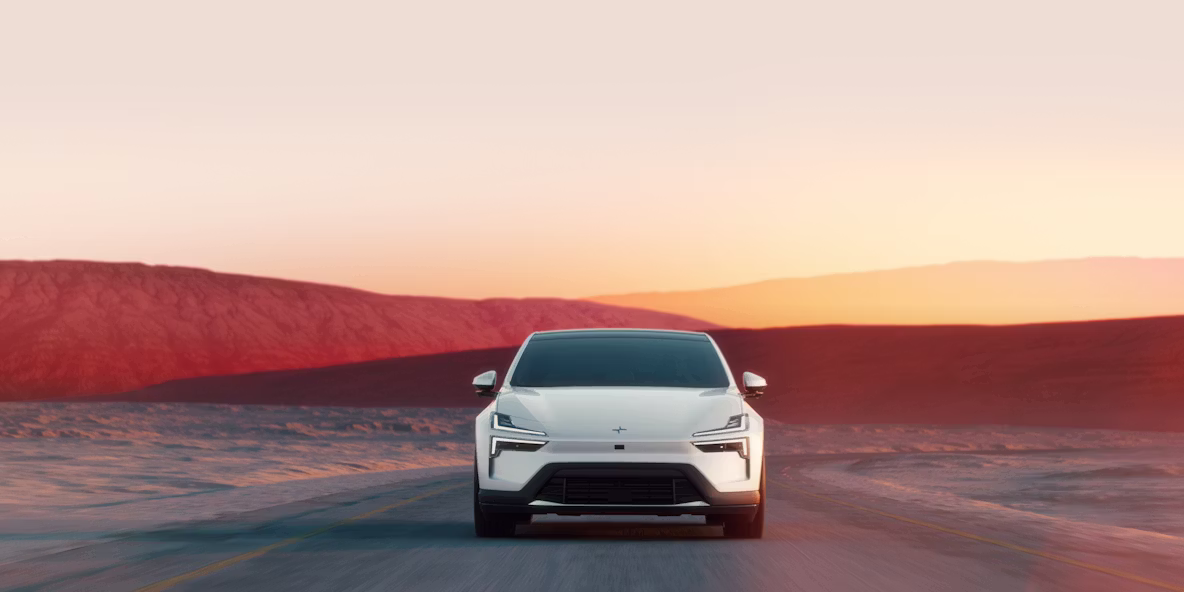 Polestar 4 coupé driving on a desert road at sunset