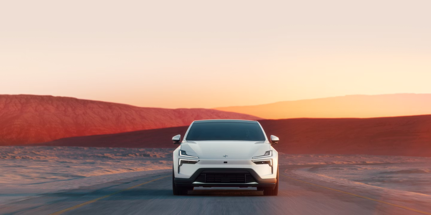 Polestar 4 Coupé driving on a desert road at sunset