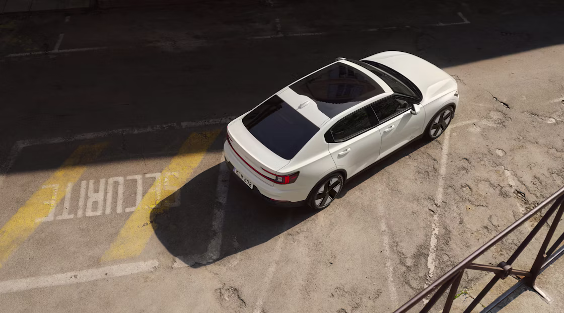 Polestar 2 standing on a parking lot with foreign lettering and worn out markings.