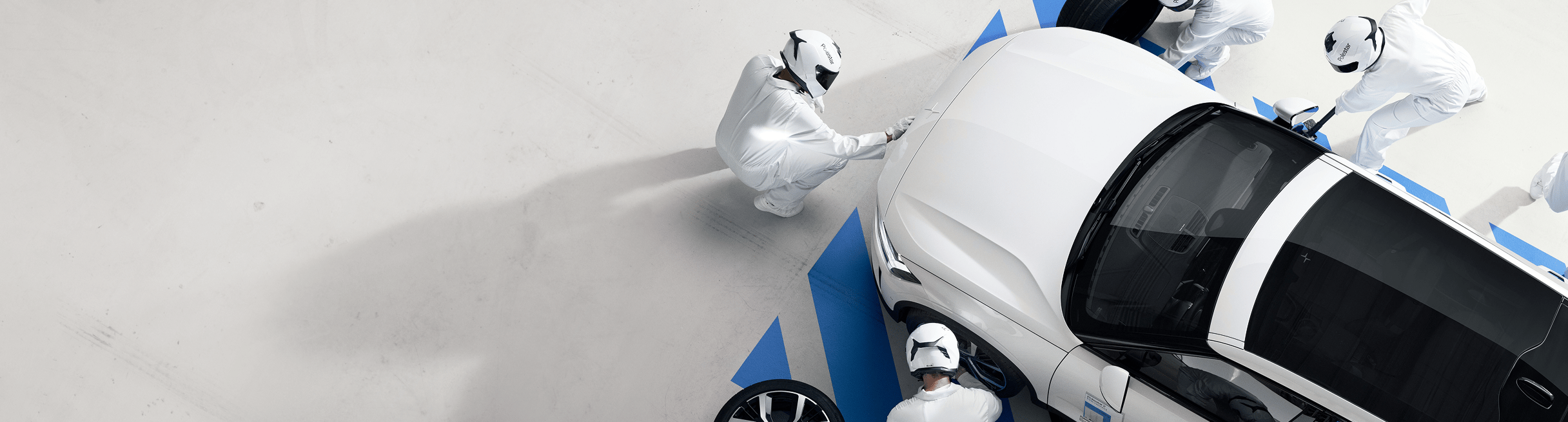 Preowned Polestar 2 being inspected by workers in white suits