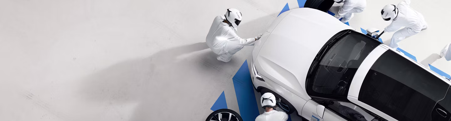 Preowned Polestar 2 being inspected by workers in white suits