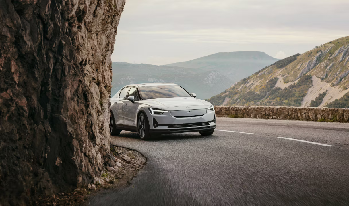 Polestar 2 on a mountain road beside a rock cliff