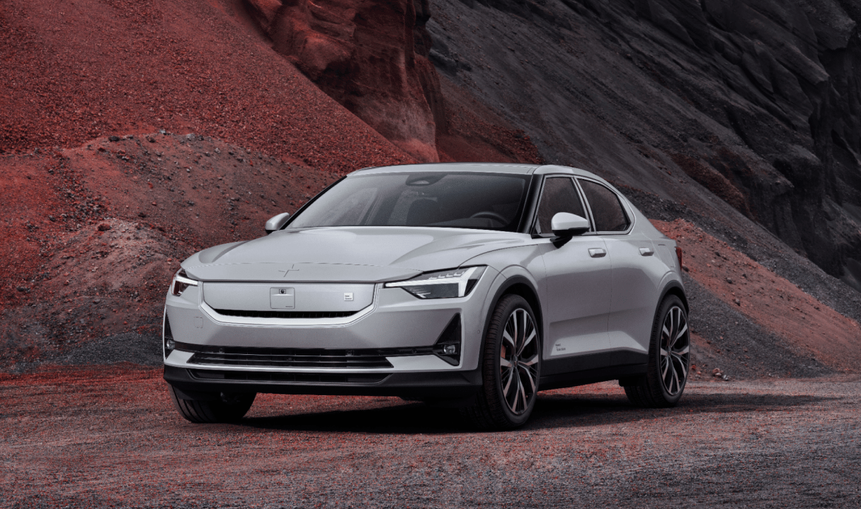 Polestar 2 parked on gravel in front of a rocky hillside