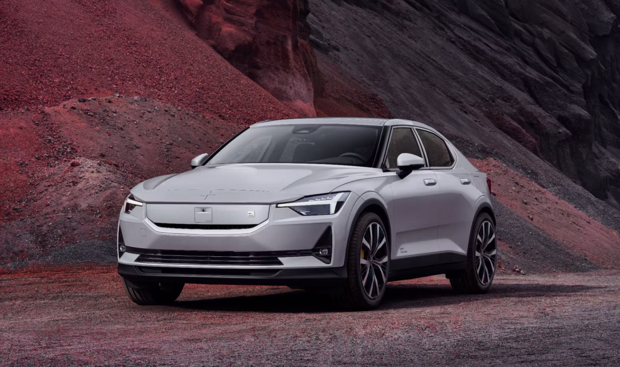 Polestar 2 parked on gravel in front of a rocky hillside