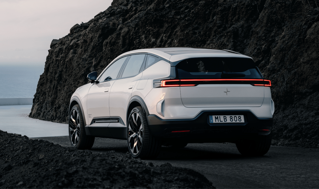 Polestar 3 SUV on a coastal road beside a rocky cliff