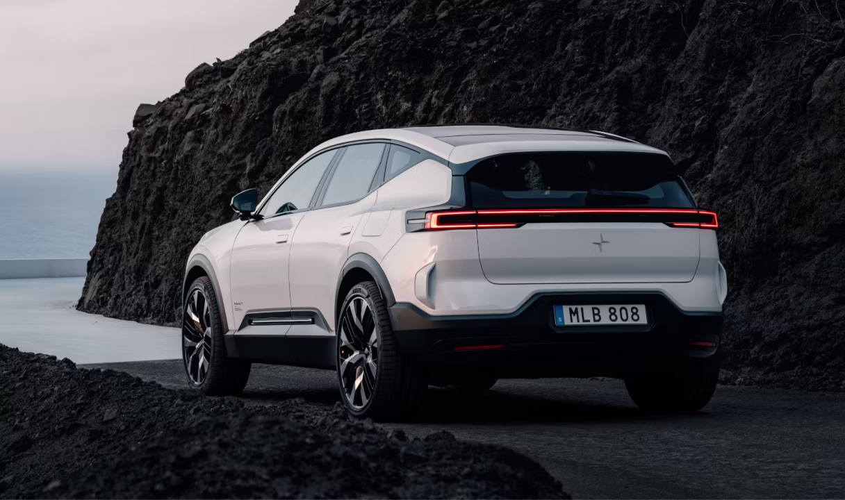 Polestar 3 SUV on a coastal road beside a rocky cliff