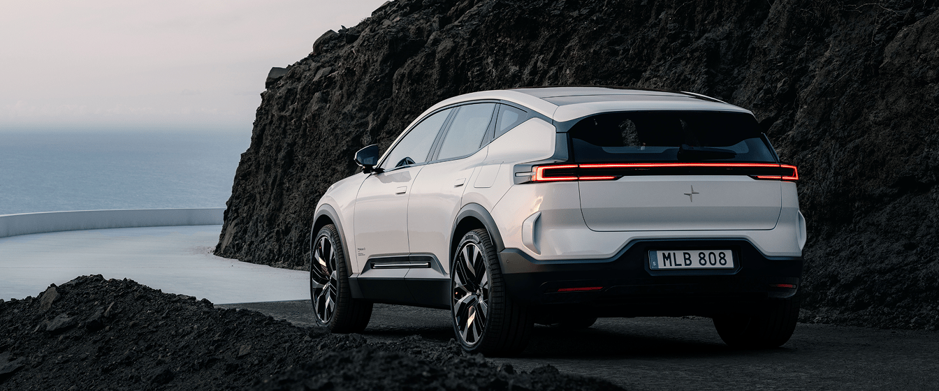 Polestar 3 SUV on a coastal road beside a rocky cliff