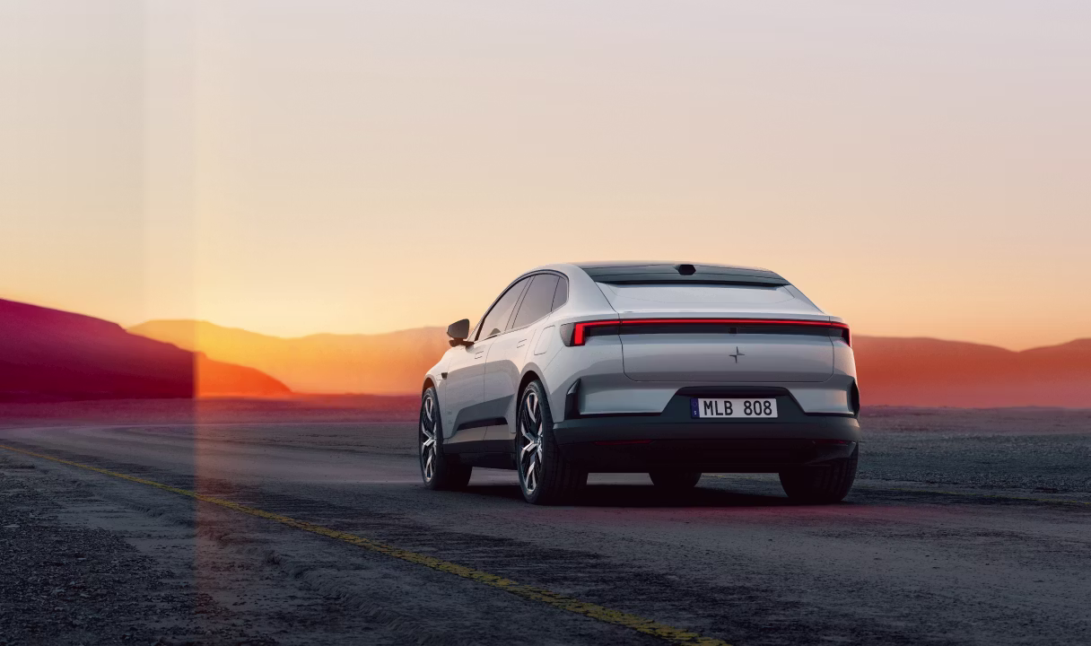 Polestar 4 coupé driving on a road at sunset