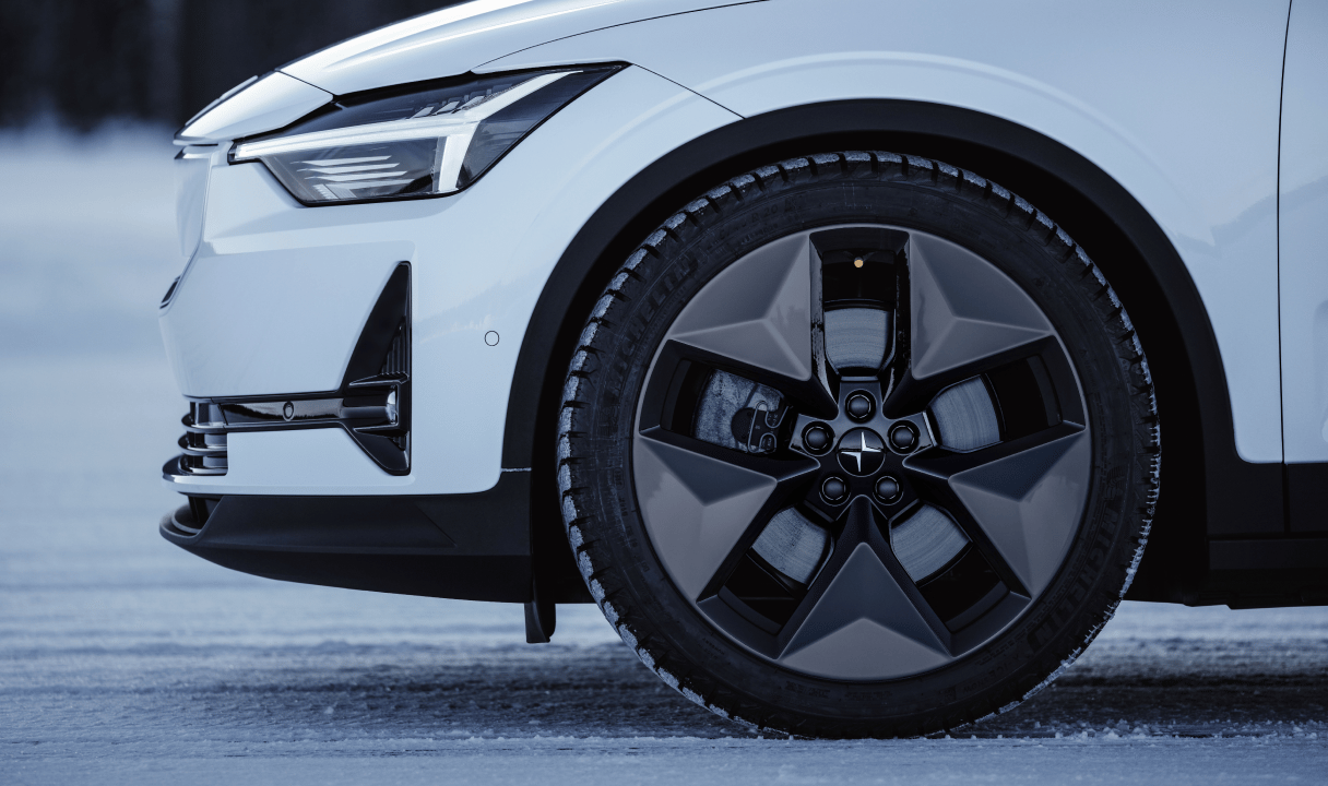 Front wheel and headlight of a Polestar 2 on a snowy road