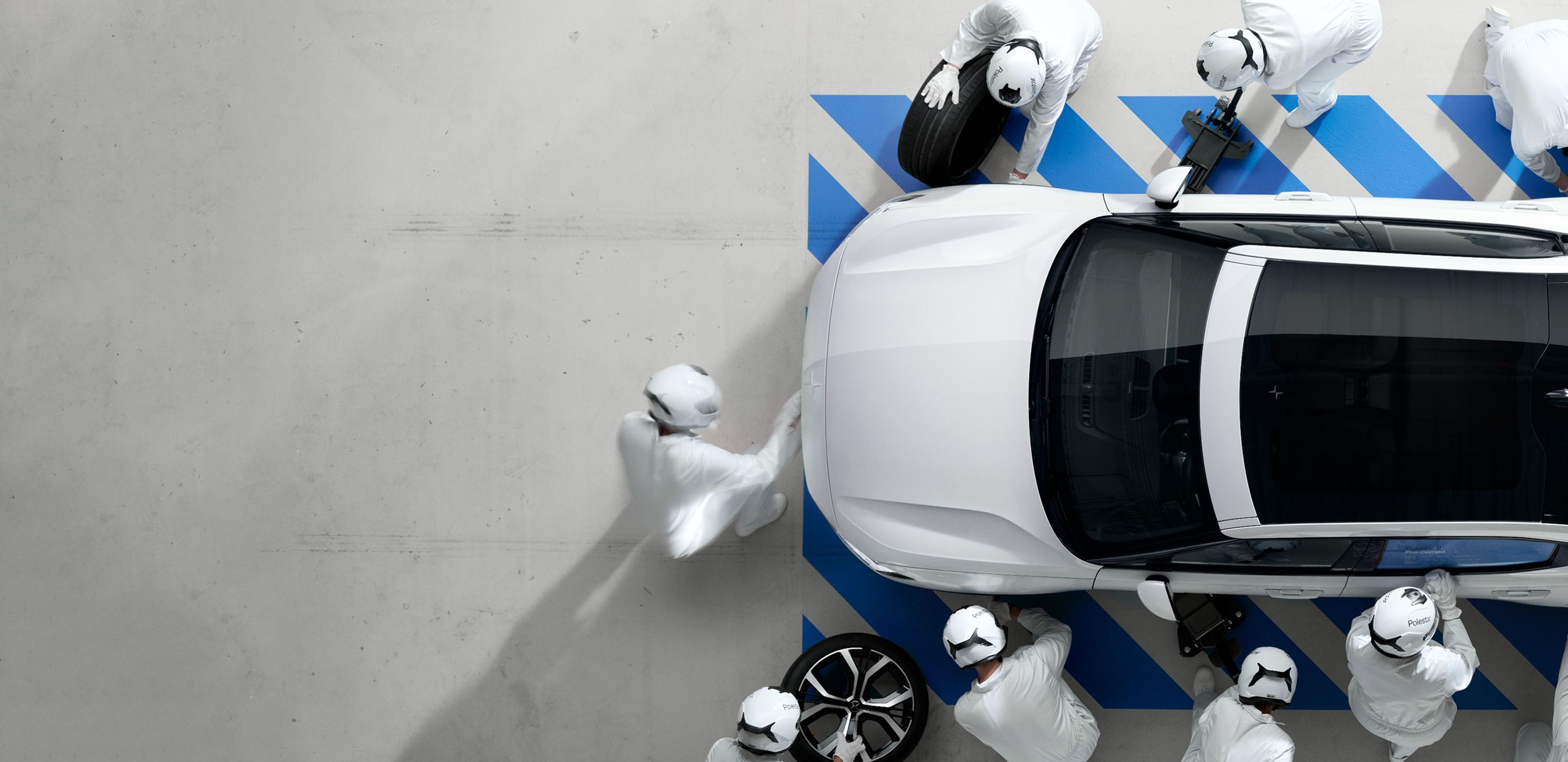 Workers inspecting a Pre-owned Polestar 2 on a factory floor