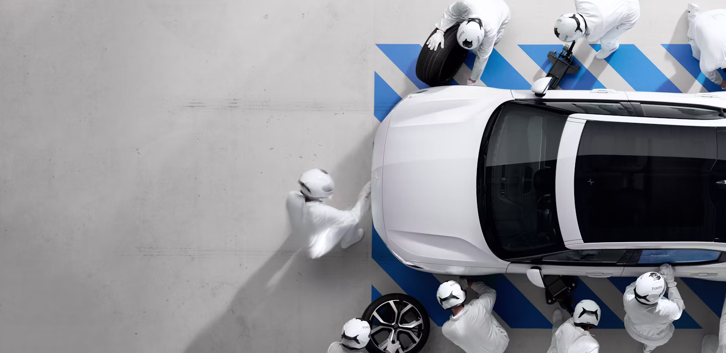 Workers inspecting a Pre-owned Polestar 2 on a factory floor