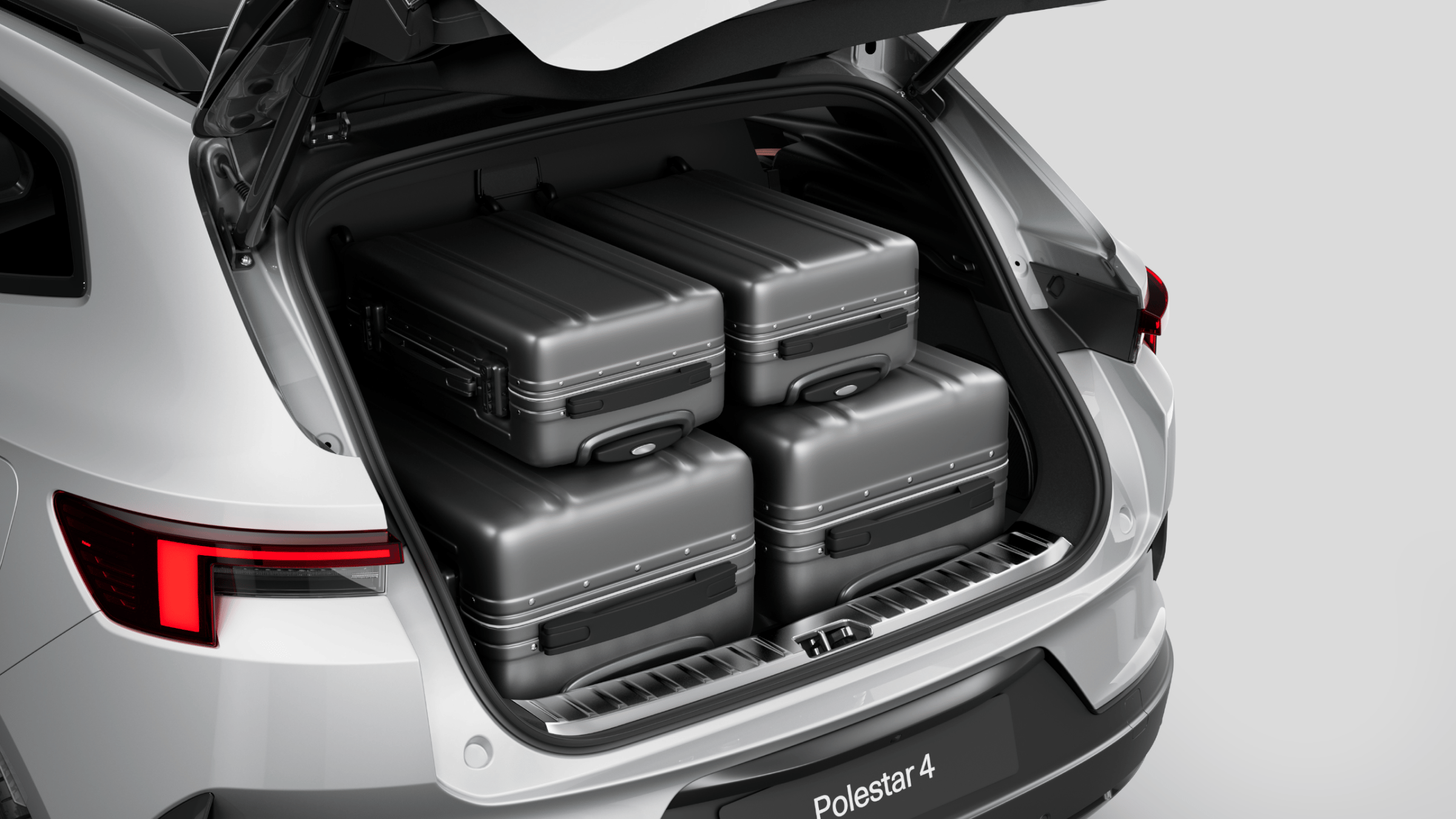 Polestar 4 SUV’s rear luggage compartment with two large suitcases and carry-on sized suitcases.