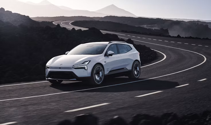 Polestar 4 SUV driving on a winding road through rocky hills